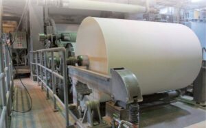 Máquina de papel com grande bobina e correntes de transmissão Tsubaki em fábrica de papel e celulose