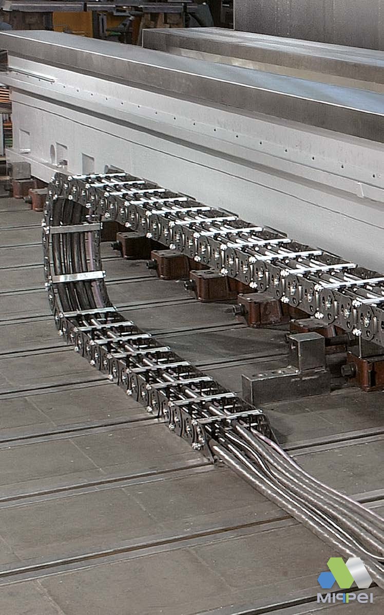 Esteiras porta-cabos de aço montadas em série numa instalação industrial